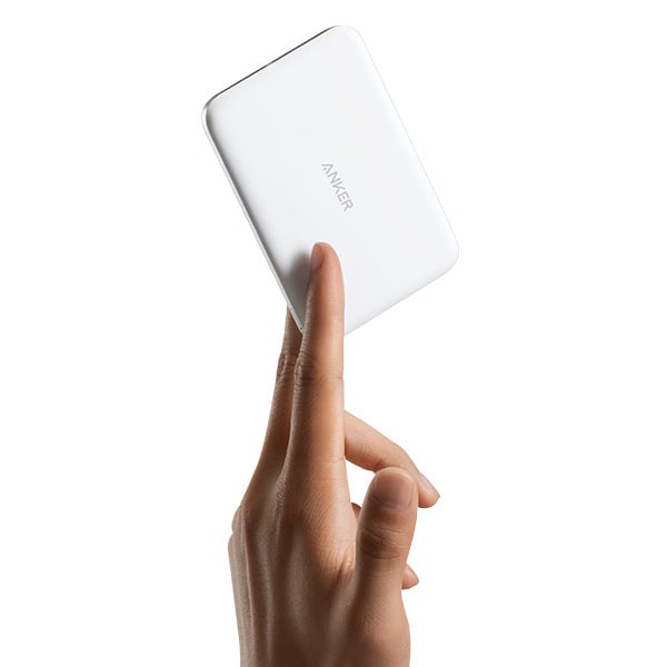 סוללת גיבוי אלחוטית לבנה של Anker Nano Slim, קומפקטית וקלת משקל, מונחת על אצבע של אדם עם רקע לבן.