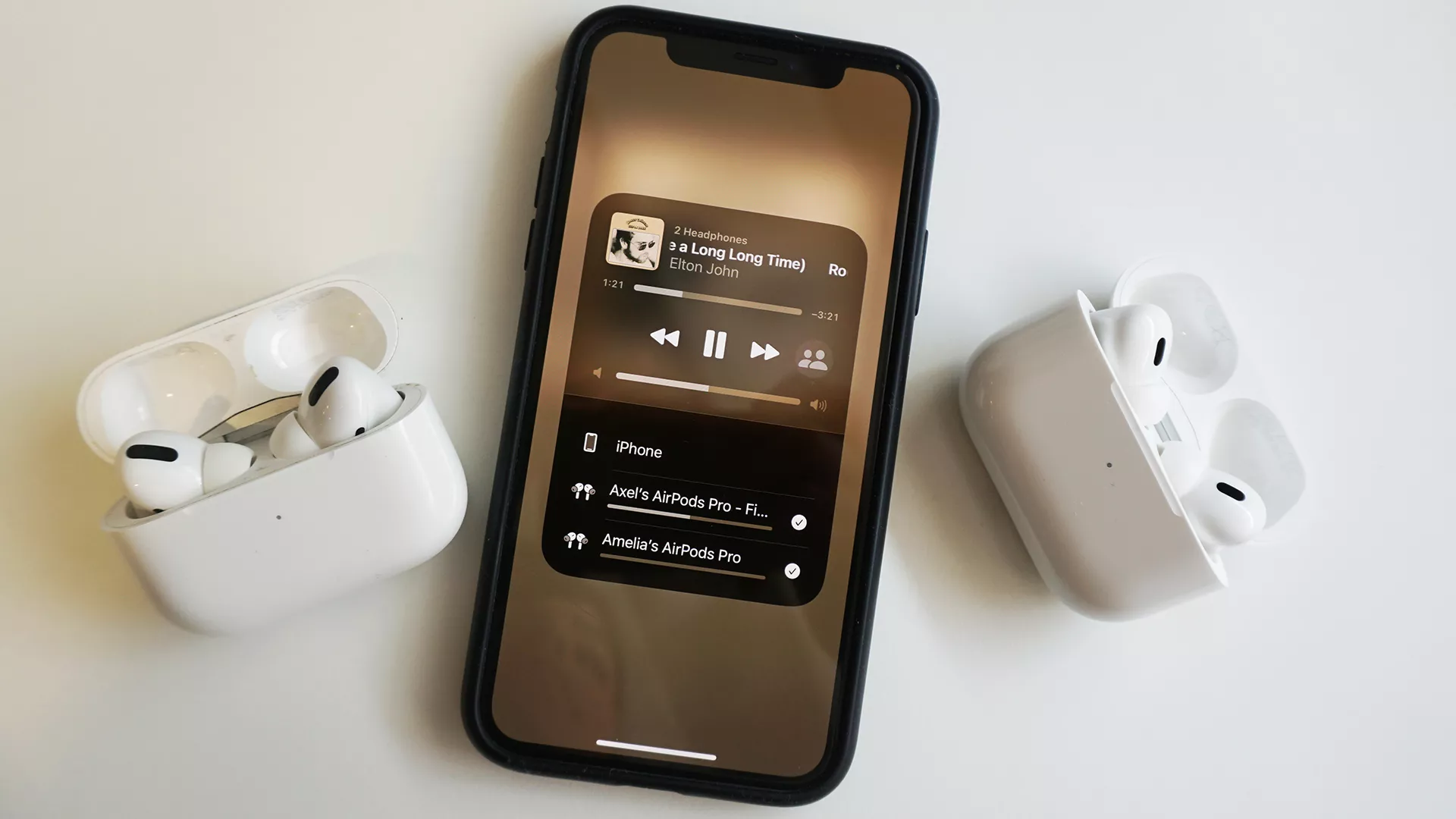 Two Pairs Of Headphones Connected To A Smartphone, Symbolizing Audio Sharing.