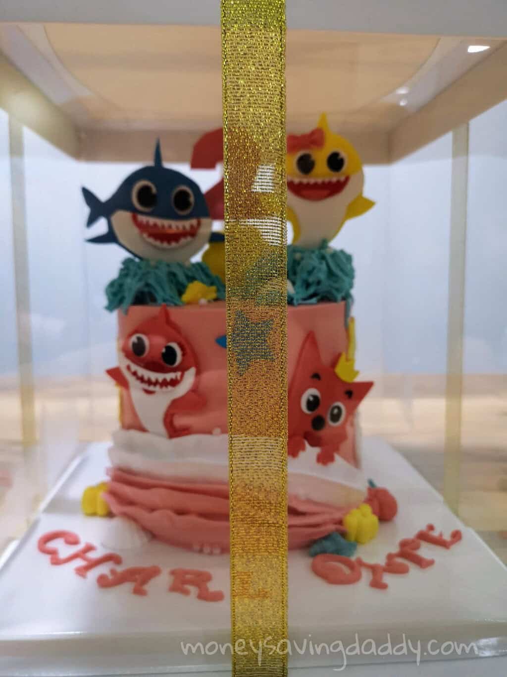 Colorful shark-themed cake with cute fish and sea creature decorations for a children's birthday par.