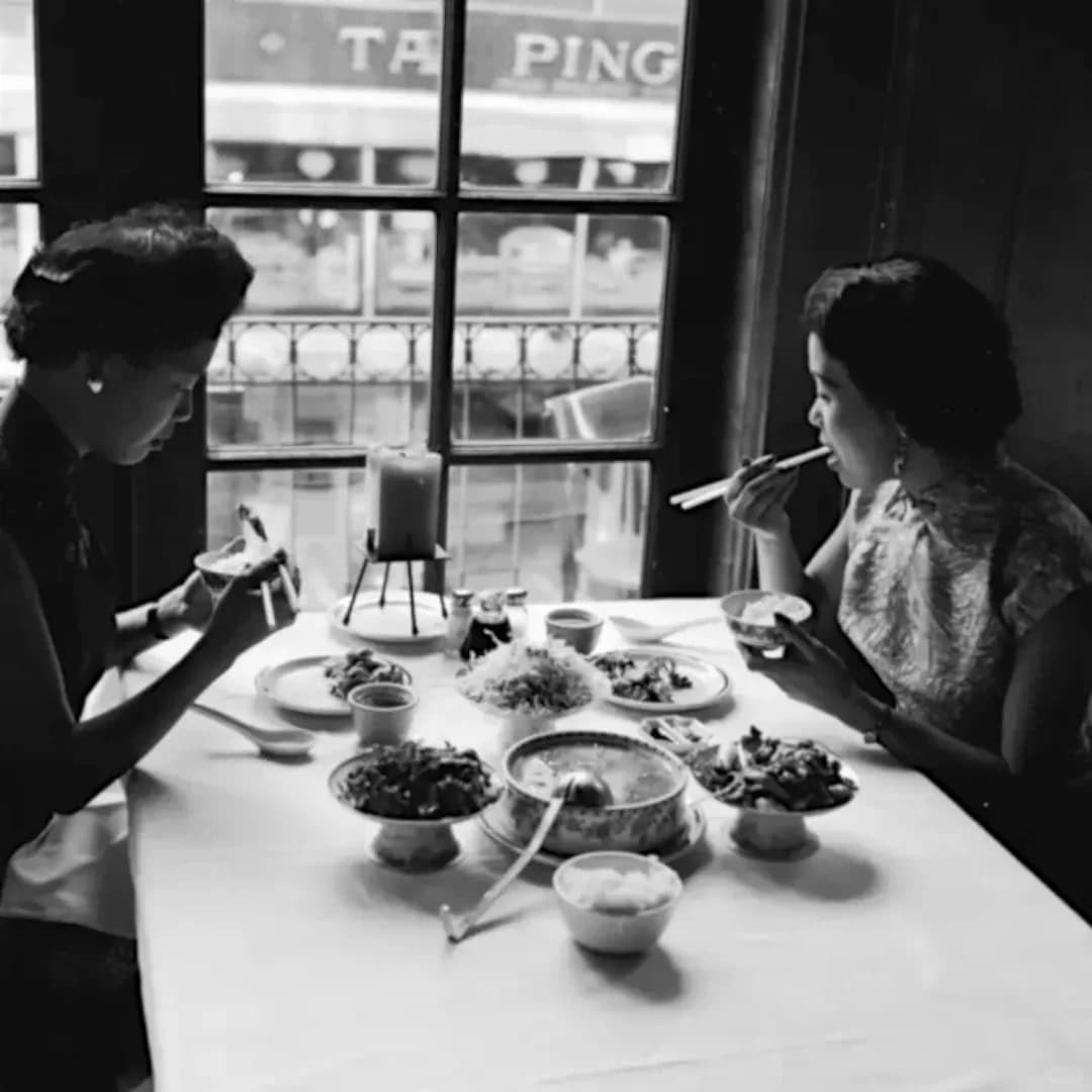 Two women enjoying a traditional meal in San Francisco's Chinatown, 1930s, showcasing the enduring culinary heritage of Taishan women.