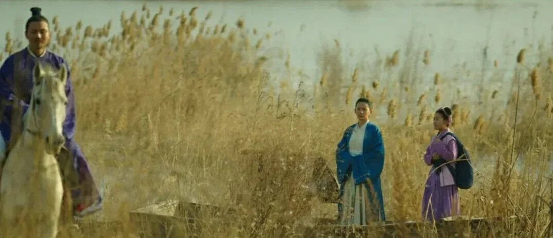 Figures in traditional robes stand and ride through a golden reed field, evoking open landscapes of Tianxia inclusion