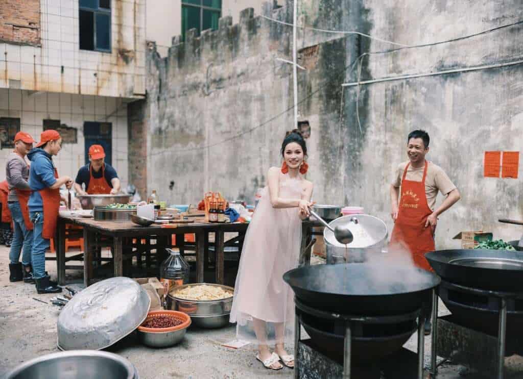 Woman smiling while preparing food for a rural wedding, showing agency in village celebrations