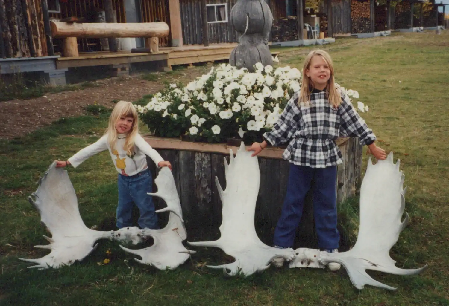 Two children with a large fish sculpture at Scoop Lake Outfitters.