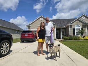 Hank the dog reunited with his grandparents outside their home after his move from Bermuda to the USA.