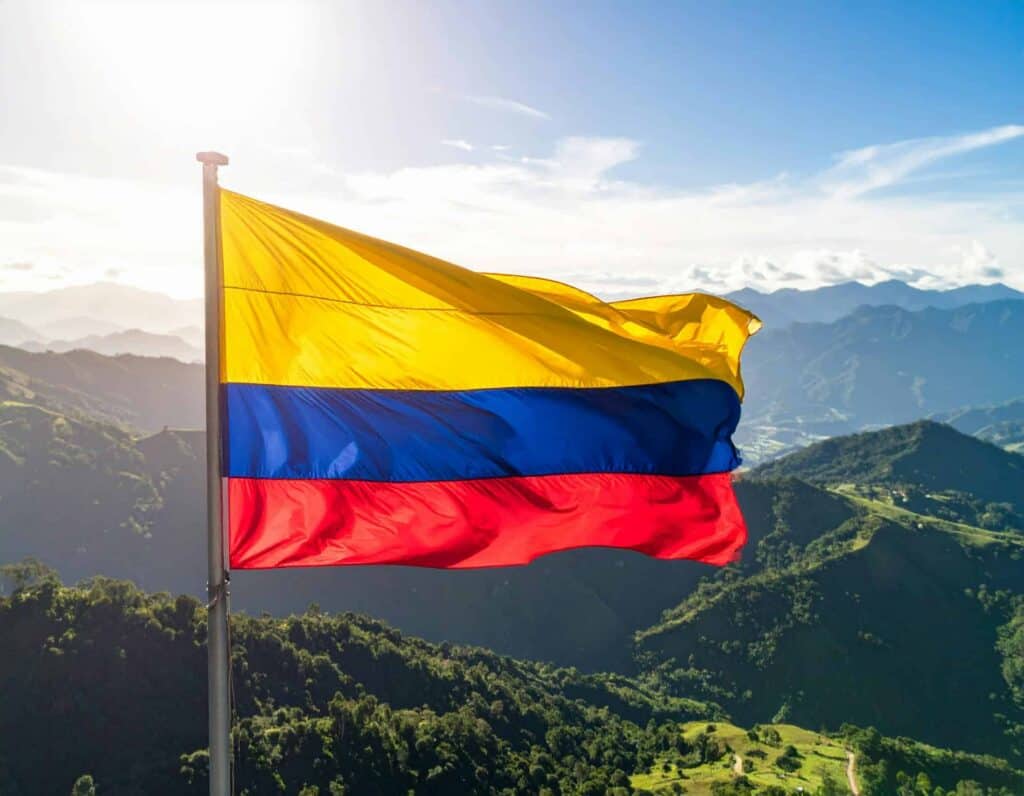 Colombian flag over a mountain landscape for a pet relocation to Colombia blog.