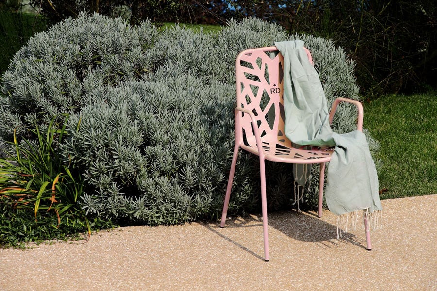 Pink Decorative Chair With A Light Green Cloth Draped Over It Outdoors.