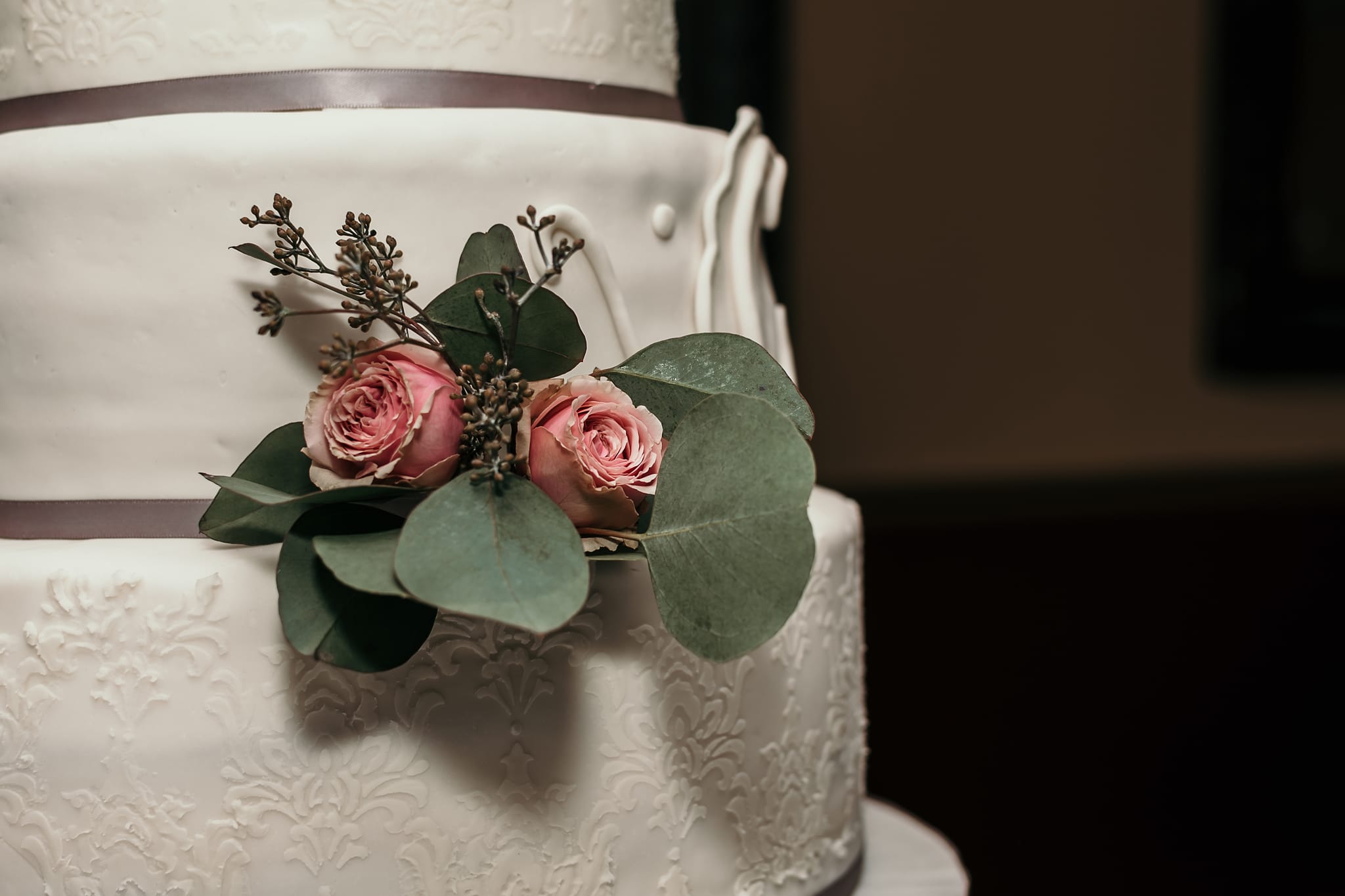 close up of fresh roses on three-tier wedding cake at intimate country club wedding