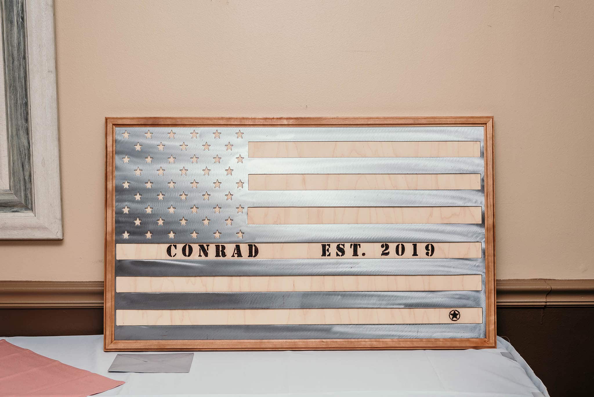 metal and wood american flag sign with bride and groom's last name and wedding date