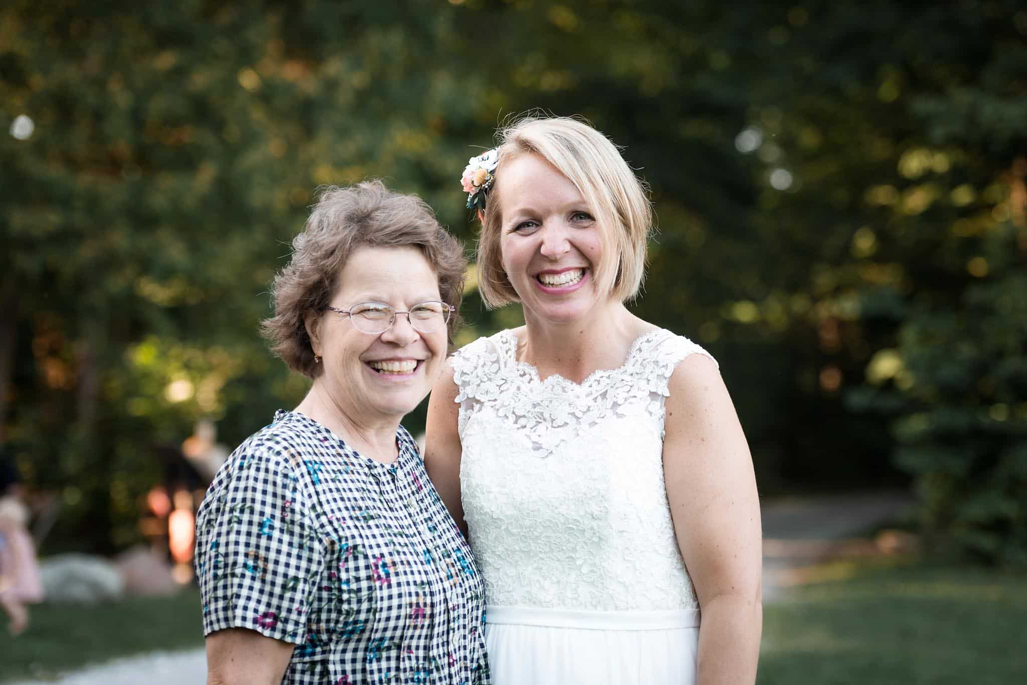 Bride posing with guest after outdoor wedding ceremony at Pokagon State Park