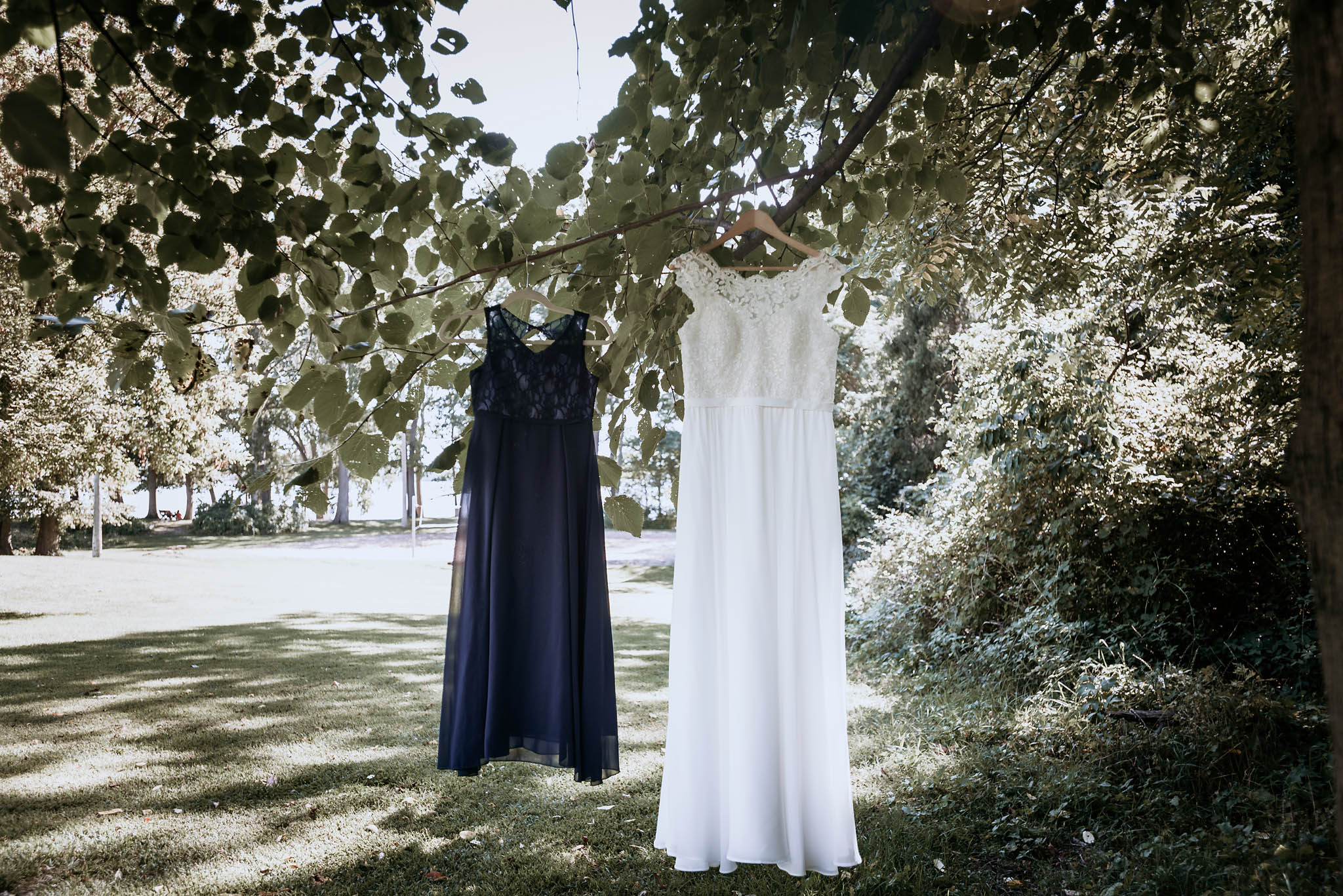Bride's wedding dress hanging with daughter's dress in a tree prior to Pokagon State Park wedding