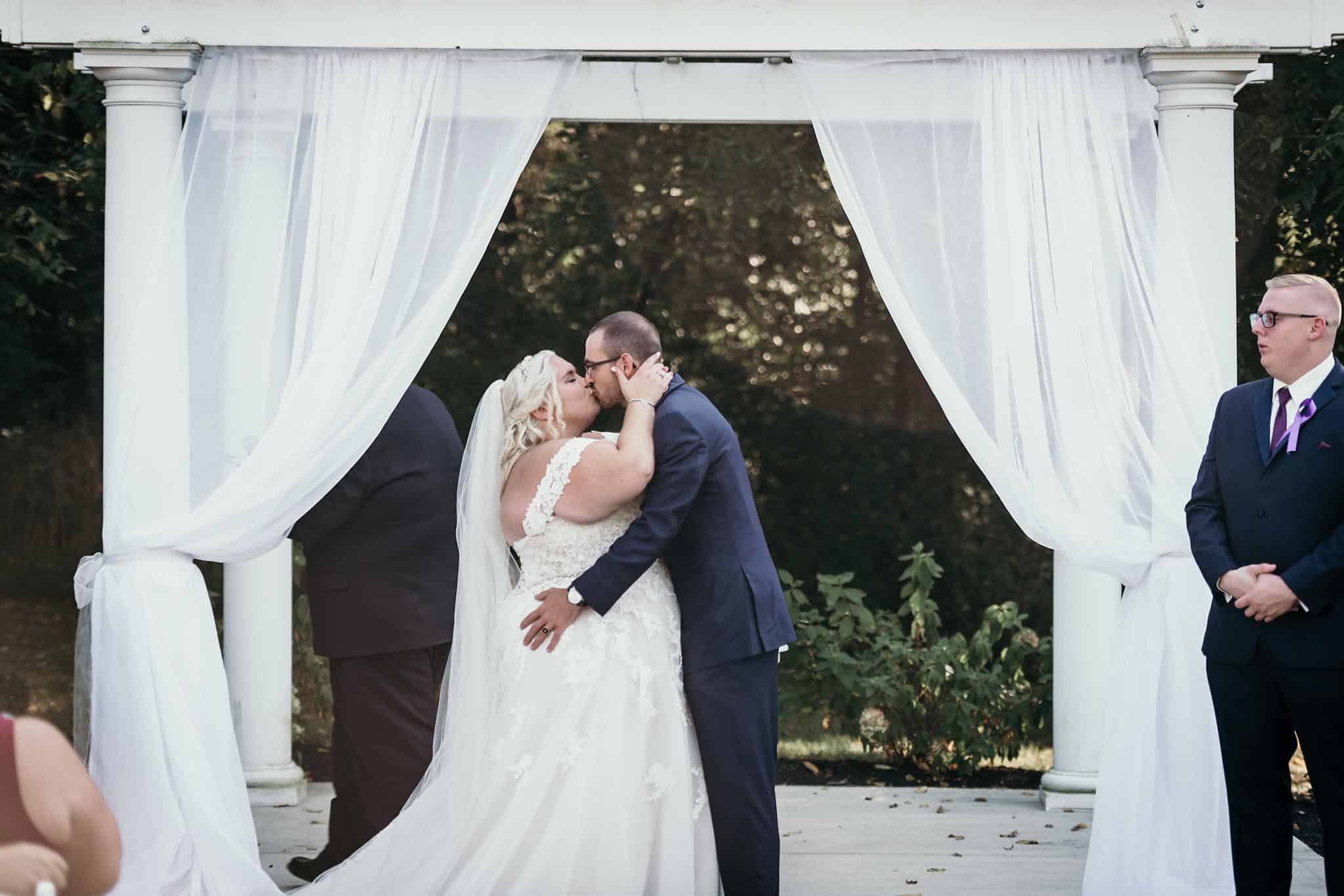 Bride and groom's first kiss after vows during intimate fall wedding
