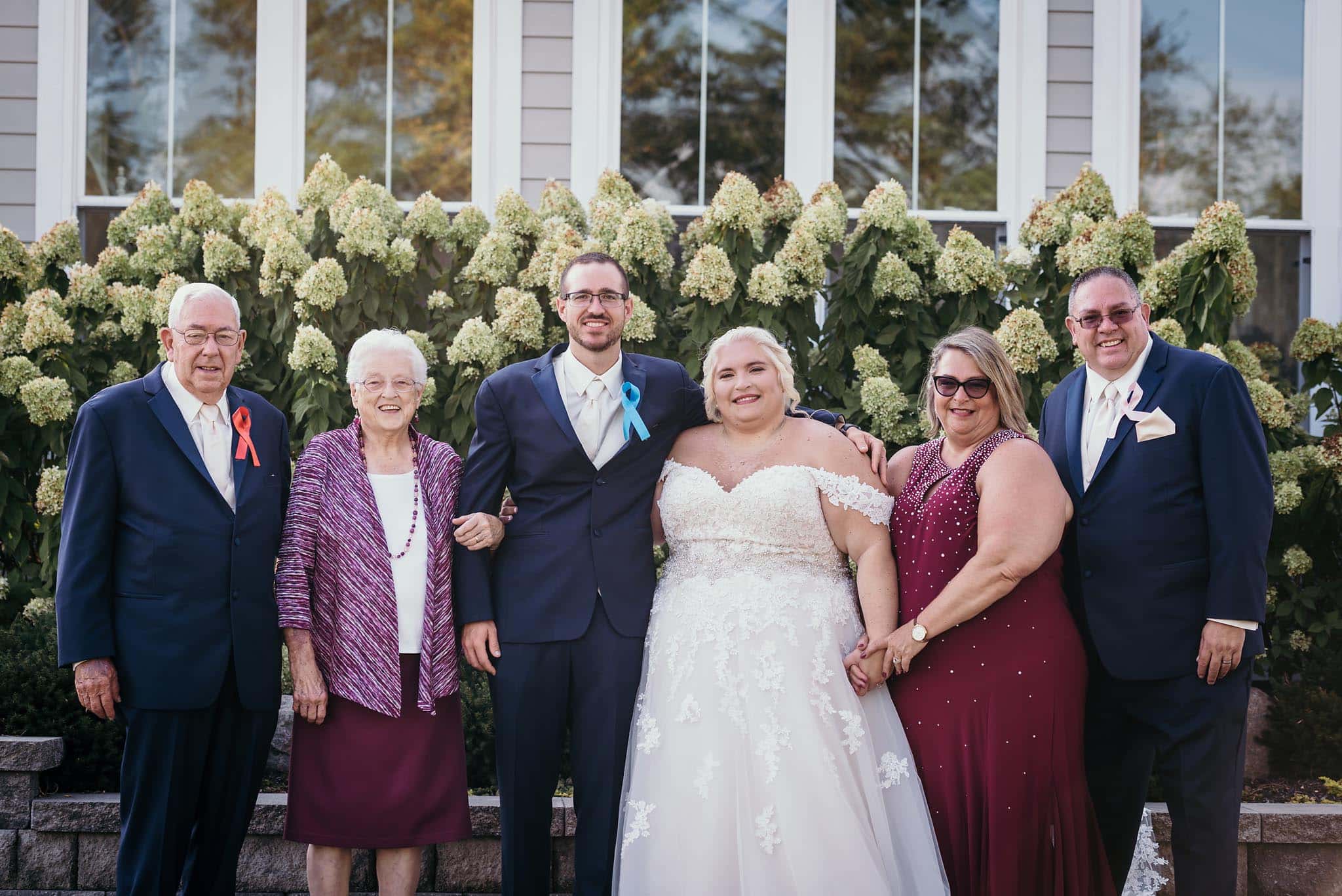 Bride and groom posing with family members