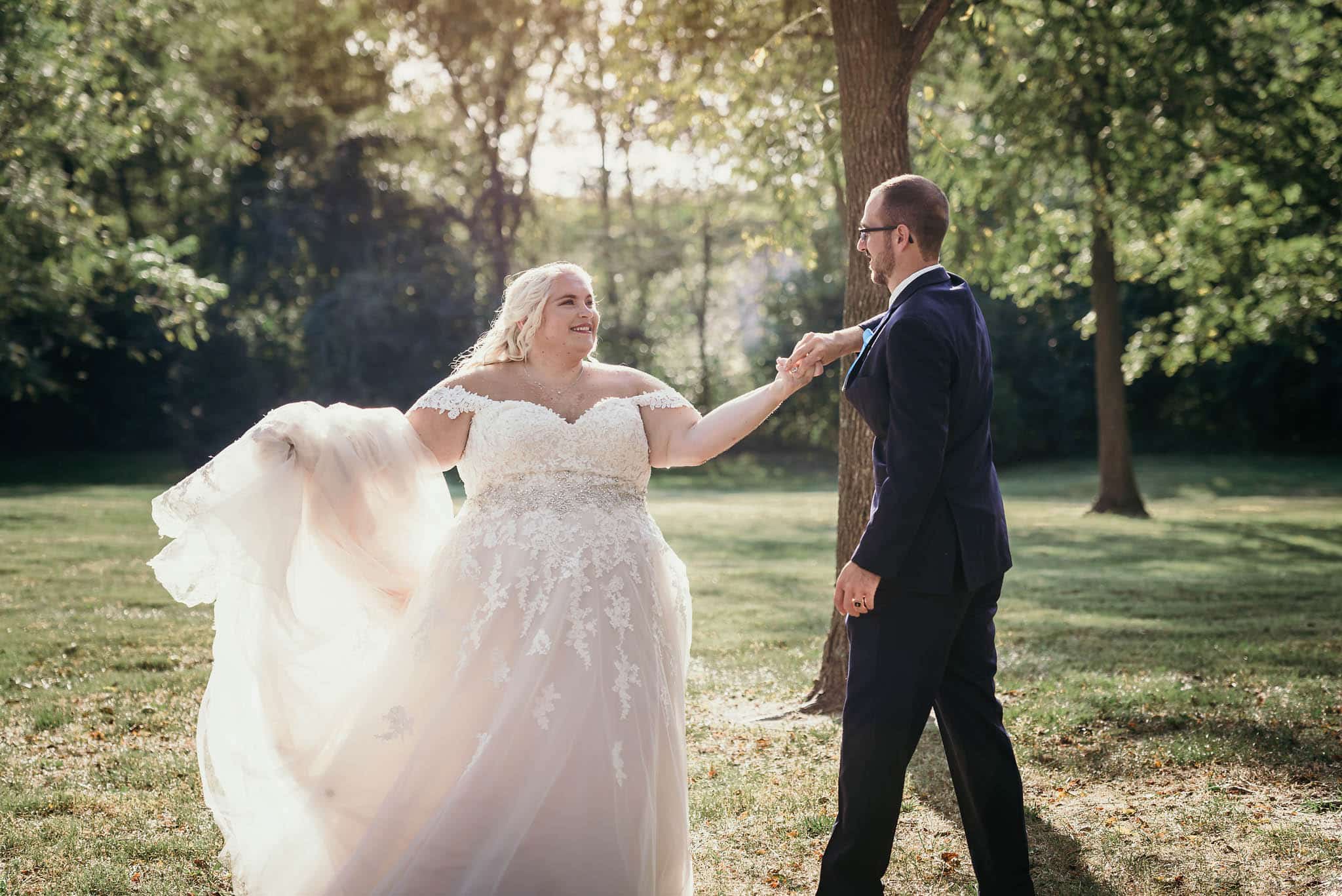 Groom twirling bride around outside during intimate fall wedding