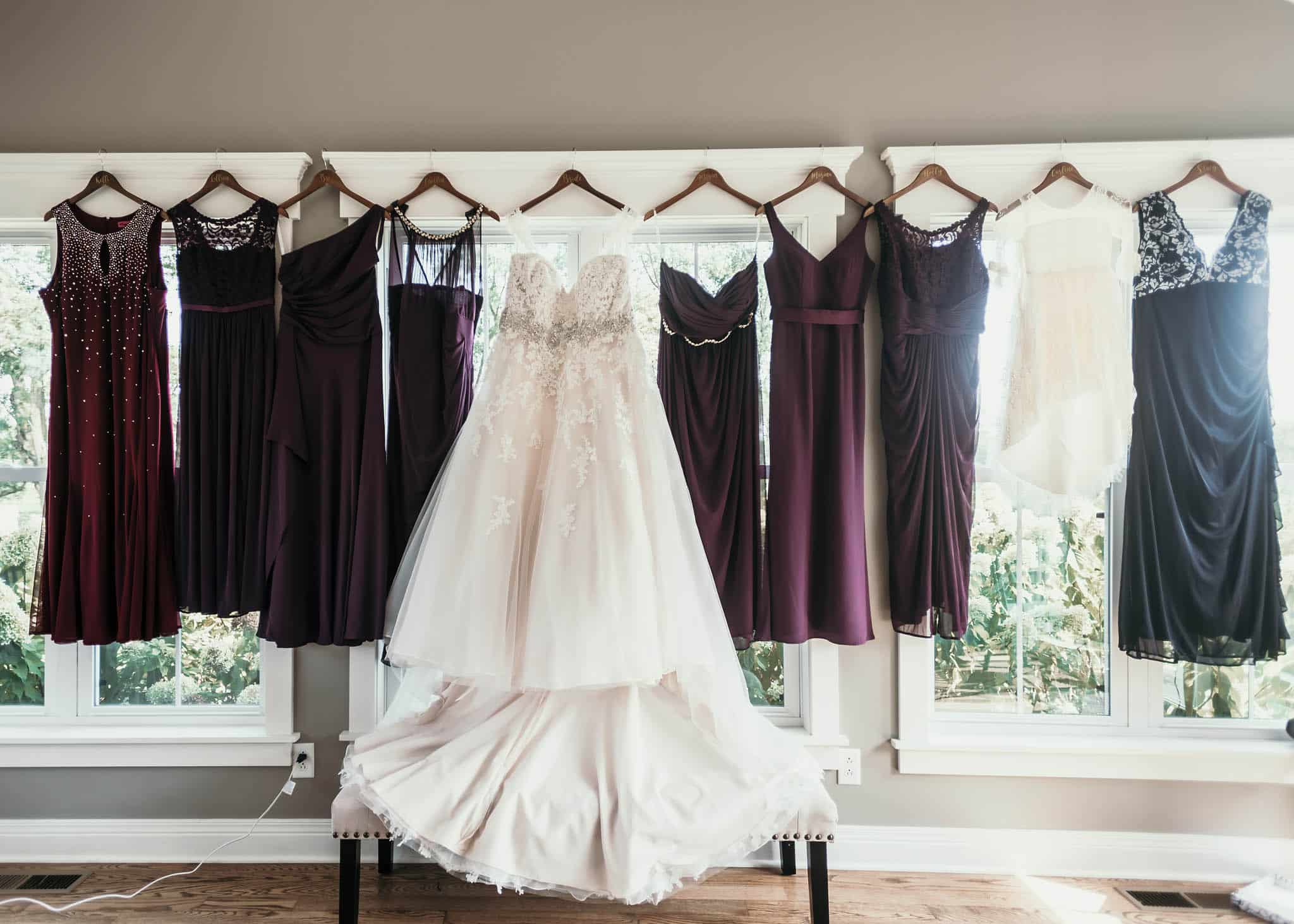 Wedding dress and bridesmaid dresses hanging on window ledge