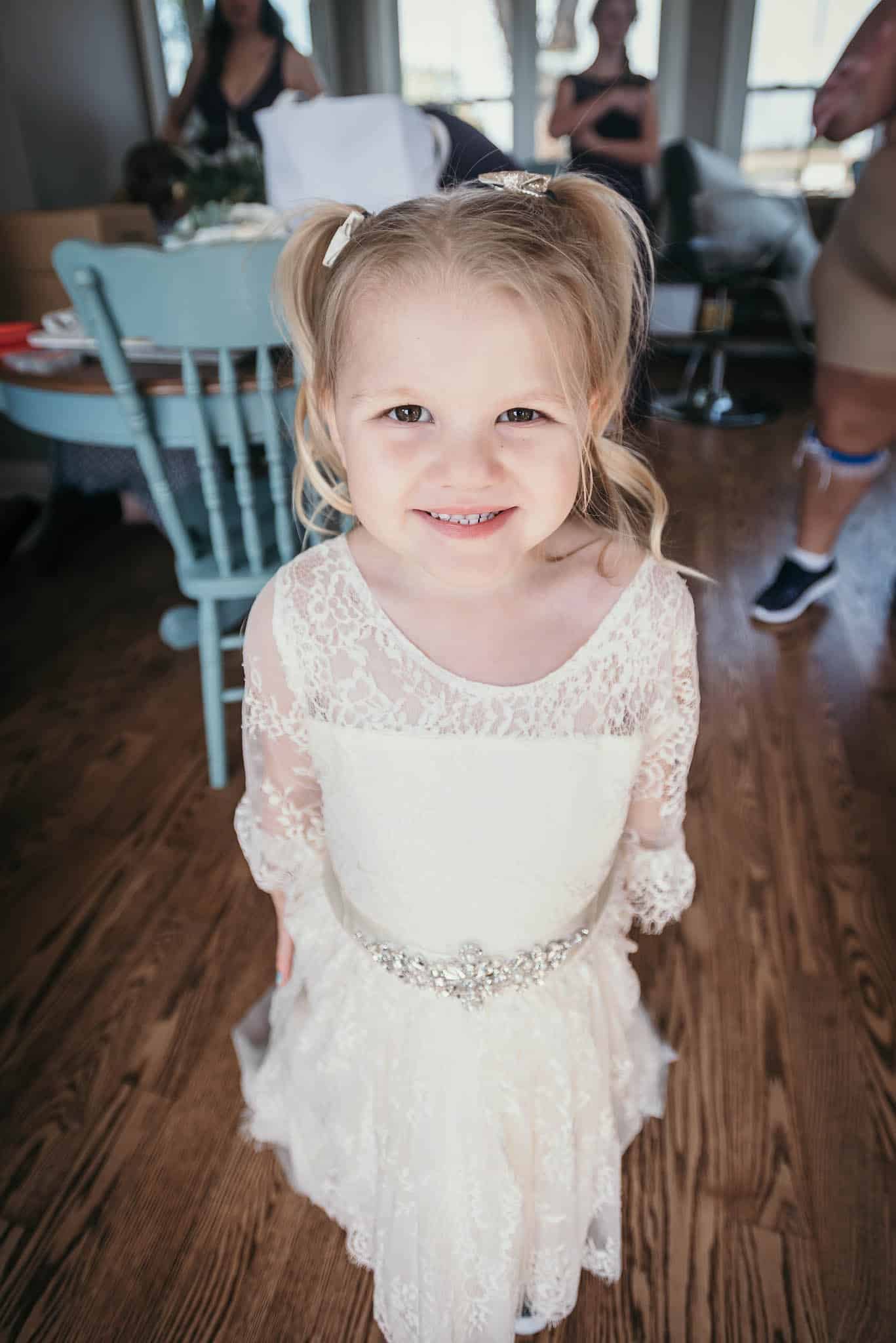 Flower girl smiling for photo at intimate fall wedding at the Lodge at River Valley in Yorktown, Indiana