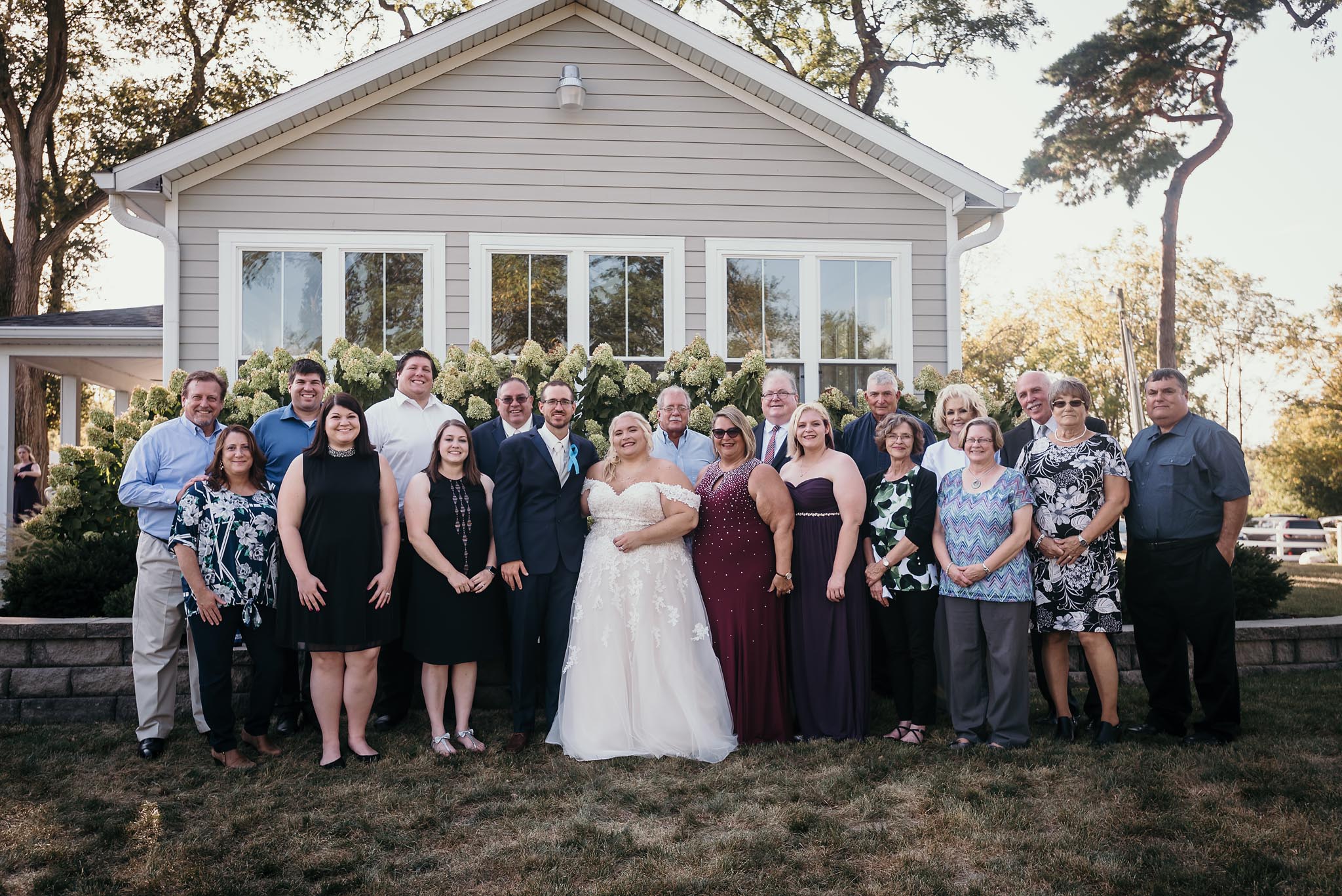 Large group family photo during outside intimate fall wedding at the Lodge at River Valley in Yorktown, Indiana