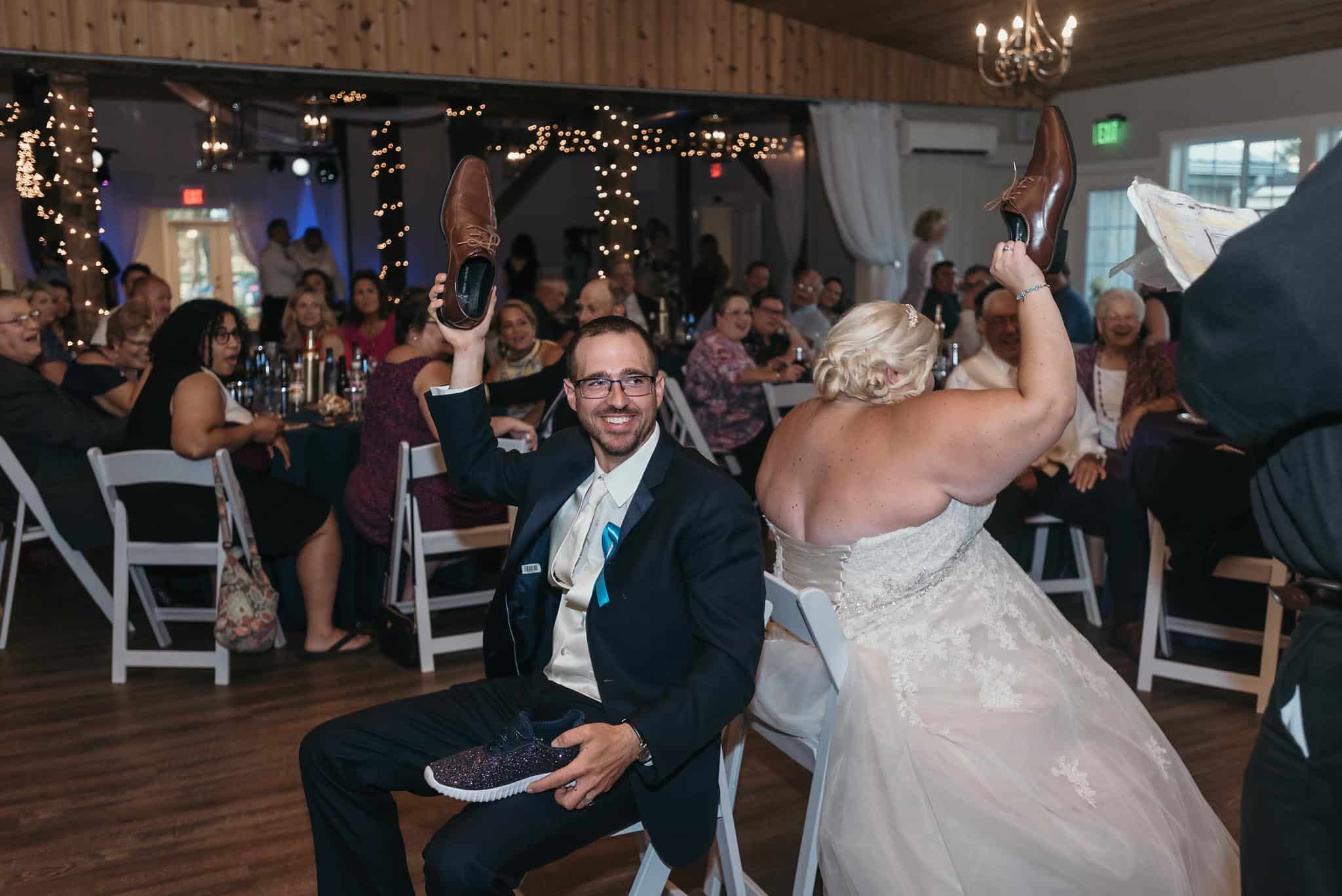 Bride and groom playing the shoe game during reception at intimate fall wedding at the Lodge at River Valley in Yorktown, Indiana