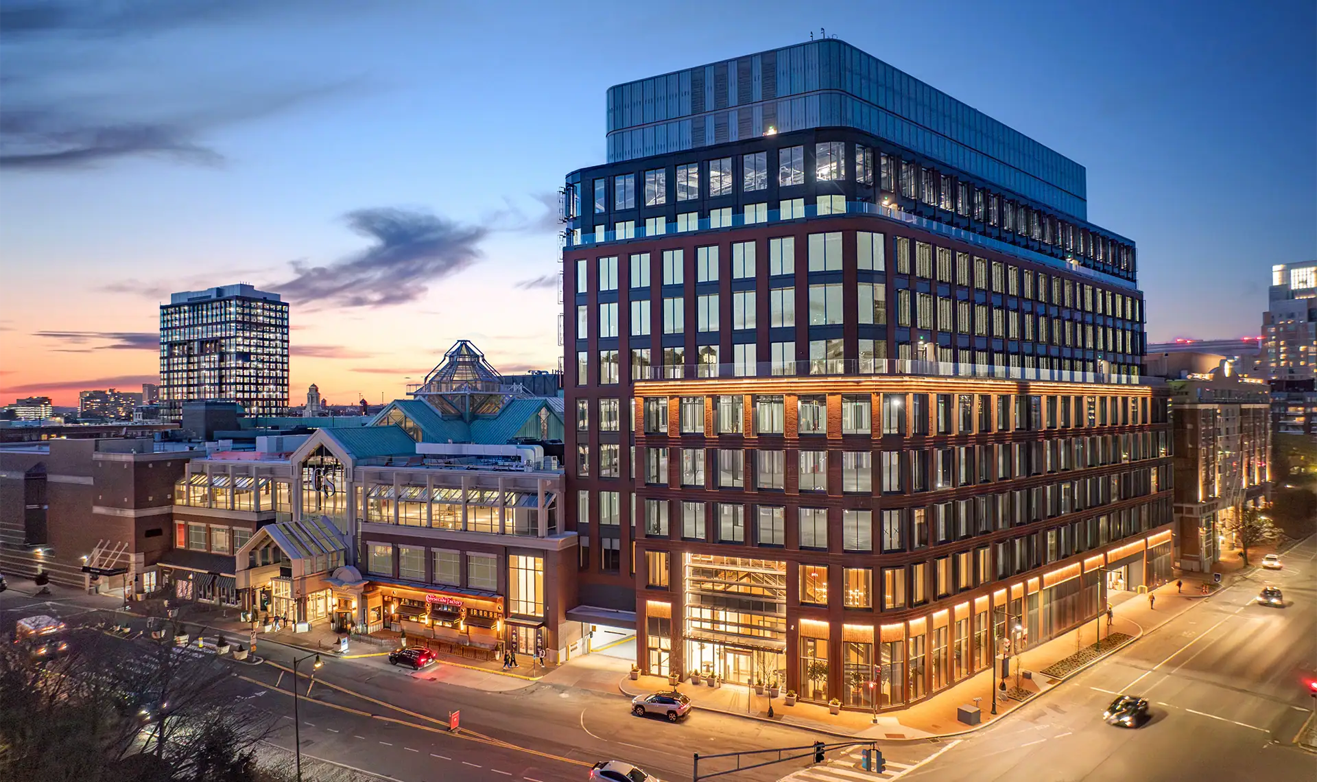 Modern multi-story office building at dusk in CambridgeSide area.