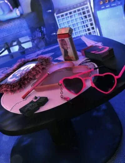 Pink heart-shaped sunglasses with chain, gaming mouse, digital art tablet with stylus, anime-themed cigarette box, and retro style art accessories on a black table with vibrant neon lighting, showcasing trendy 3D digital assets.