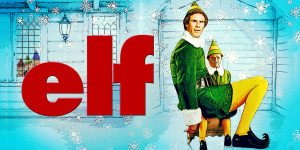 Elf character sitting on a chair in a festive Christmas scene with snow and holiday decorations.
