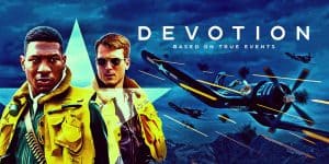 Two men in yellow jackets with fighter jets in the background for Devotion film review.
