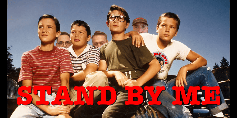 Group of five young boys sitting outdoors, with one boy in the center wearing glasses, under a clear.