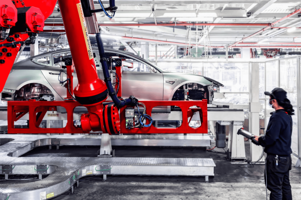 Automotive manufacturing robots assembling electric vehicle Tesla chassis on an assembly line Tesla Berlin Gigafactory.