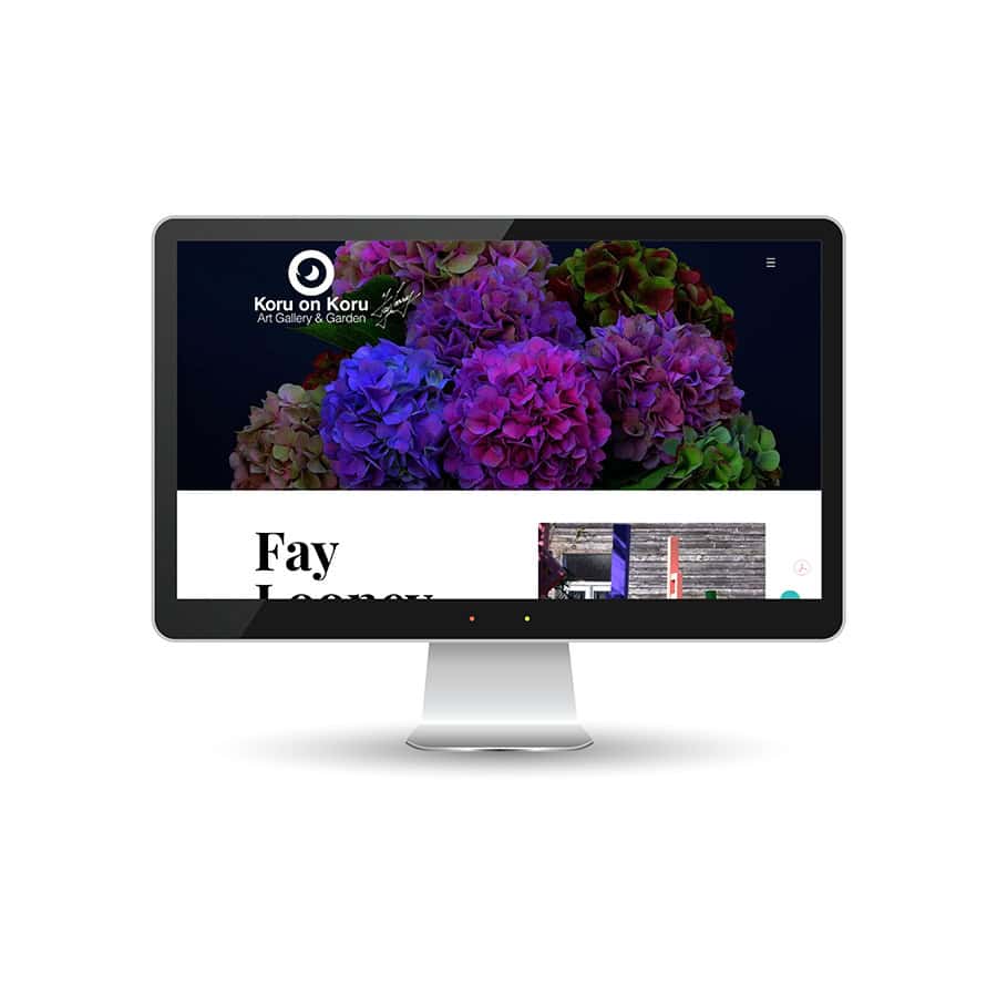 Digital display of Koru Art Gallery & Garden website on a monitor.