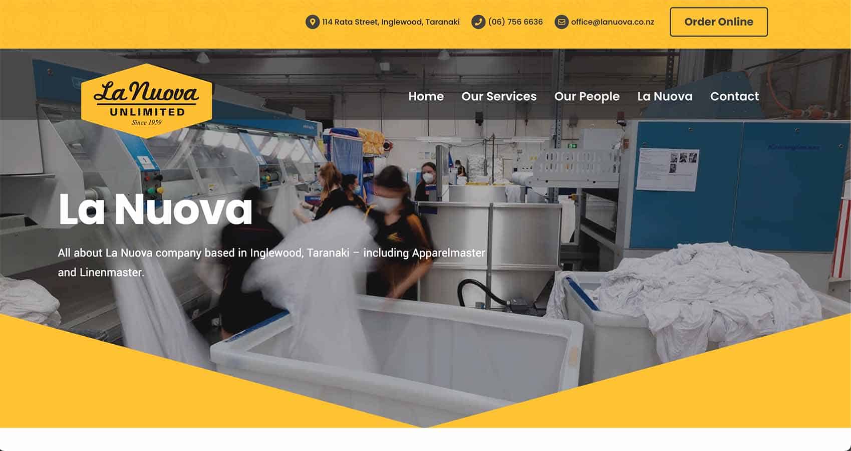 Laundry workers in a commercial laundry facility with industrial washing machines, masks, and linen, highlighting professional textile cleaning services.