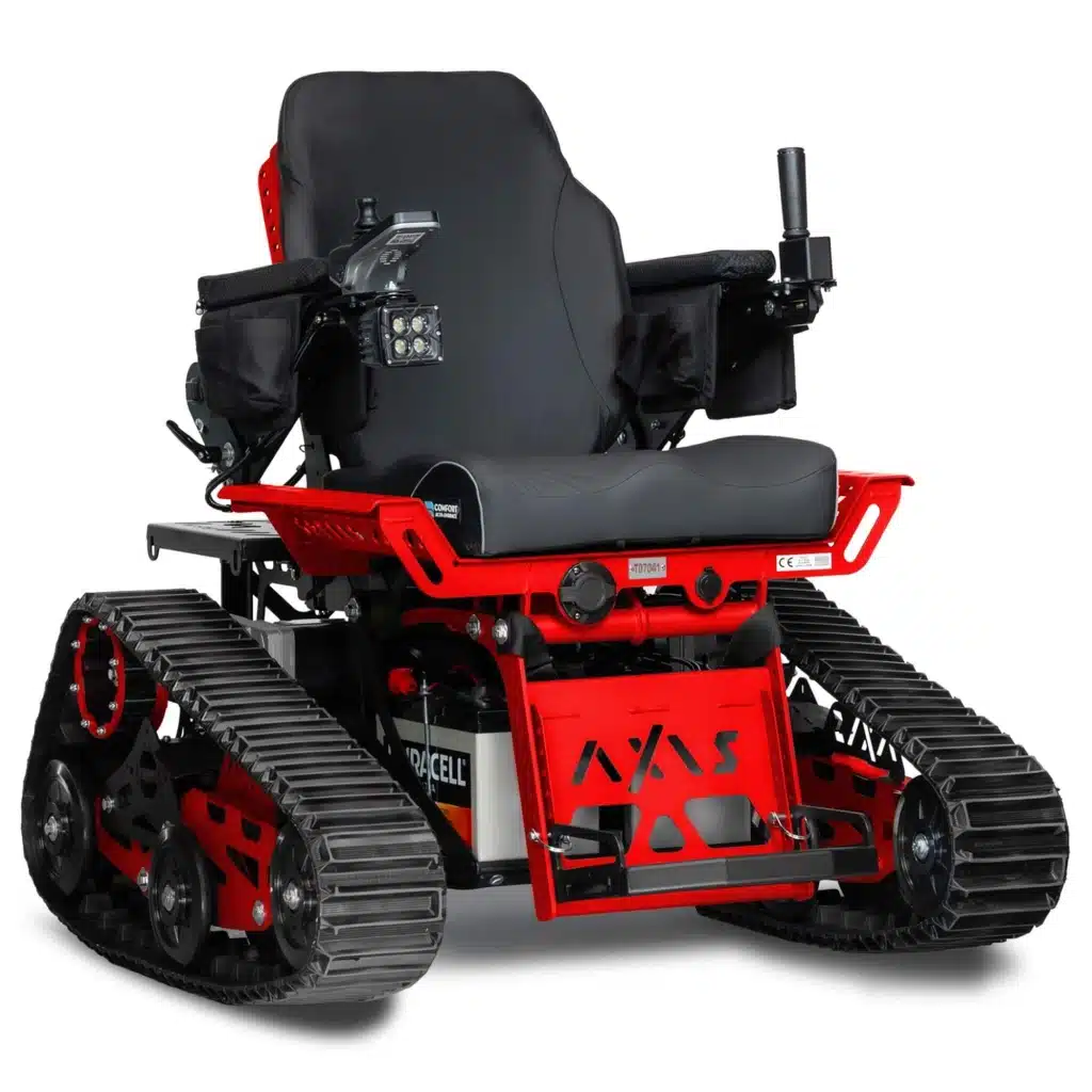 A red and black all-terrain electric wheelchair with tank-like rubber tracks instead of wheels, equipped with a joystick control on the armrest.