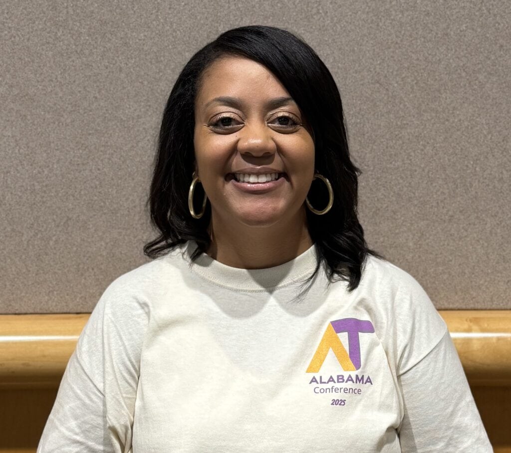 APTAT Advisor Kandis Chapman wearing a white Alabama Conference 2025 shirt, smiling at the camera