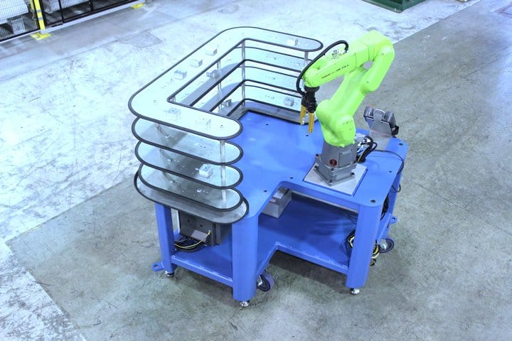 Industrial robotic arm with safety barriers in manufacturing setting.