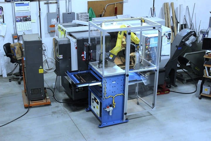 Robotic arm working inside a protective enclosure.