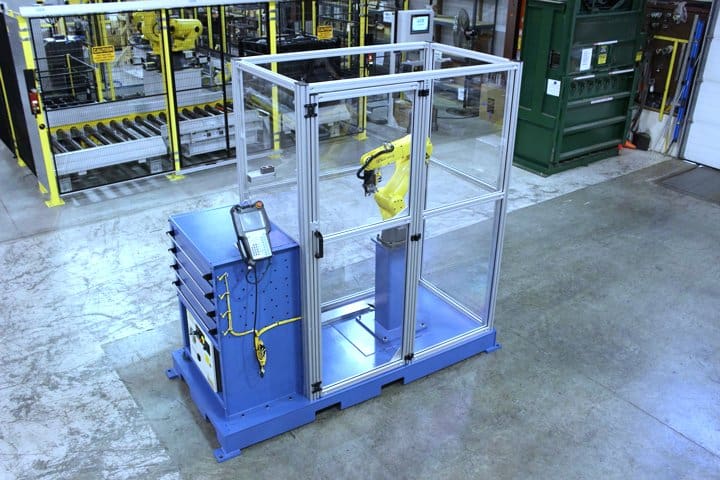 Robotic arm enclosed in safety glass for industrial automation at Adaptec Solutions.