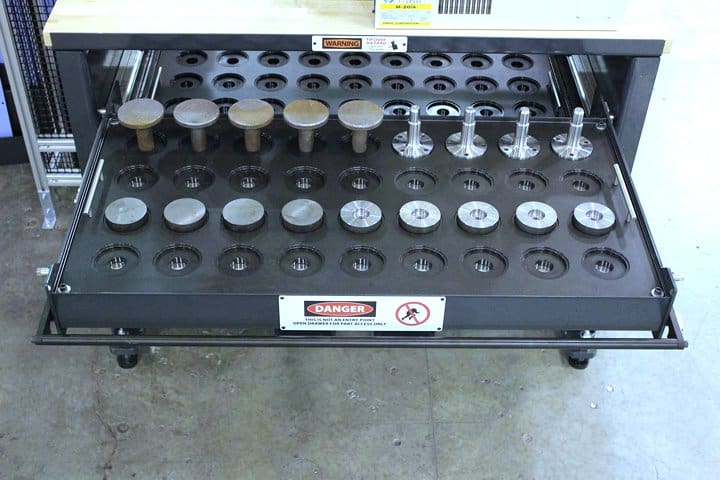 Test equipment rack with various gauges and connectors for calibration.