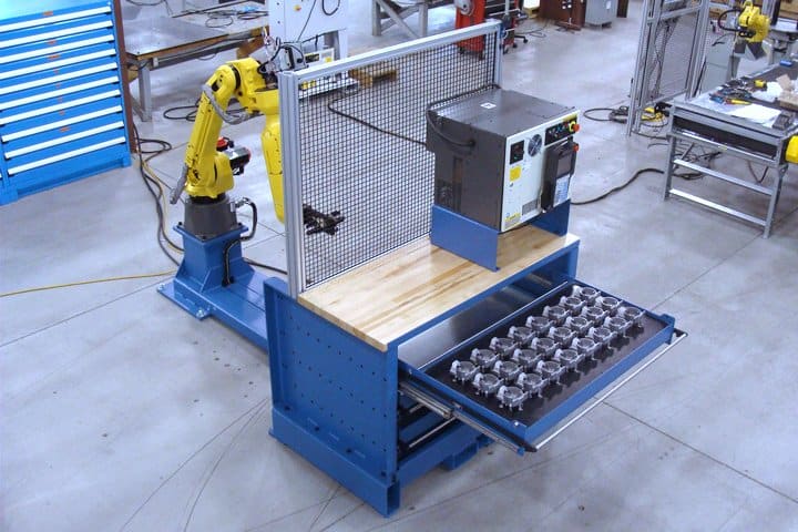 Robotic manufacturing system with automated parts handling.