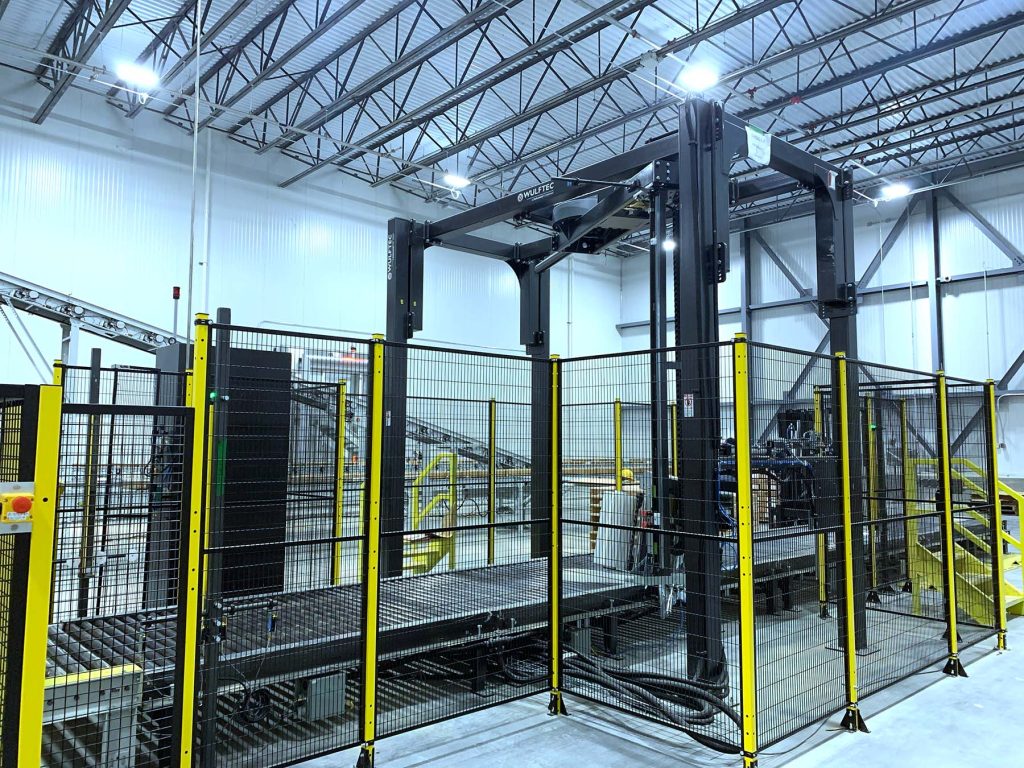 Automated stretch wrapper machine used for secure pallet wrapping in industrial warehouses.