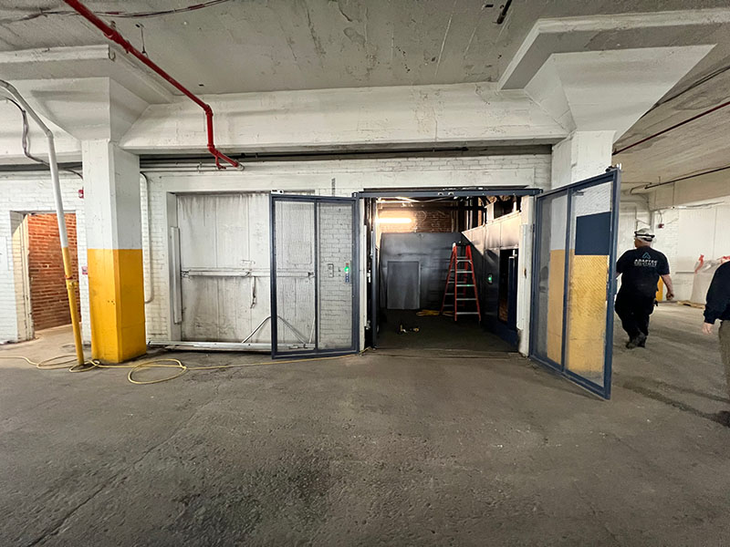 Adaptec Solutions warehouse entrance with open doors and workers nearby.