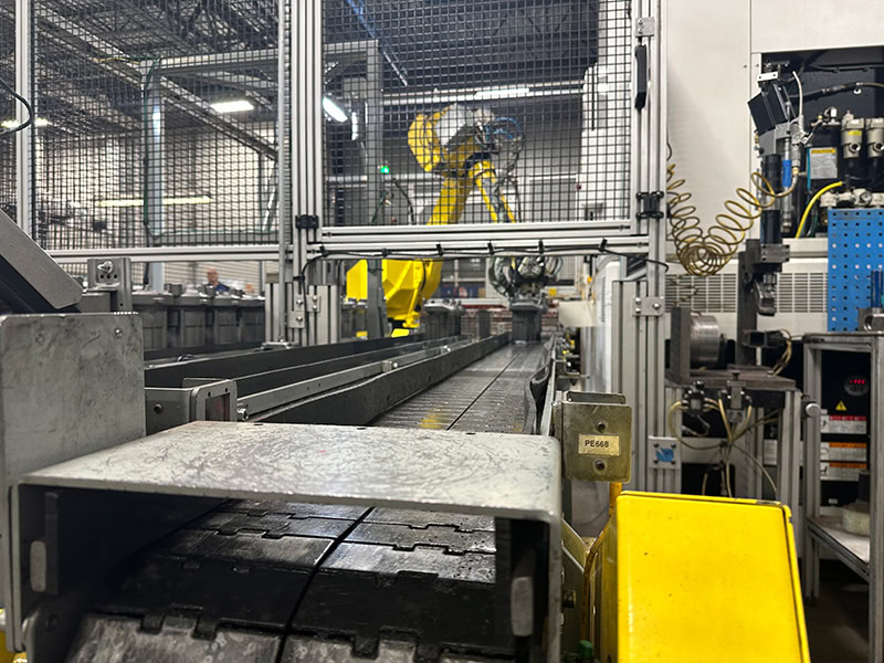 Robotic arm performing automated assembly in a manufacturing facility.