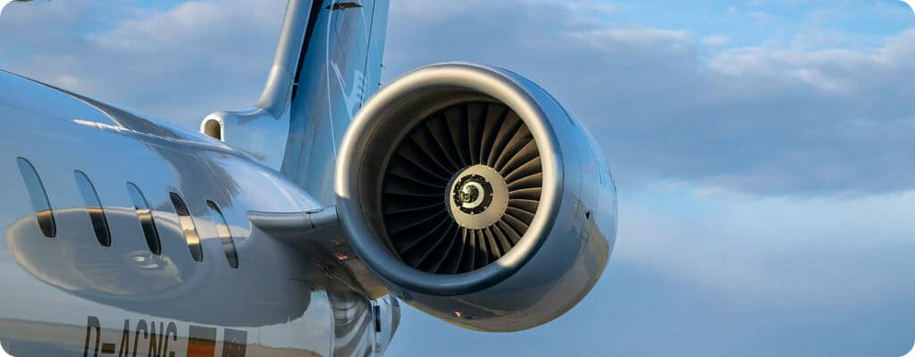 Close-up of a jet engine on an aircraft in flight against a blue sky.