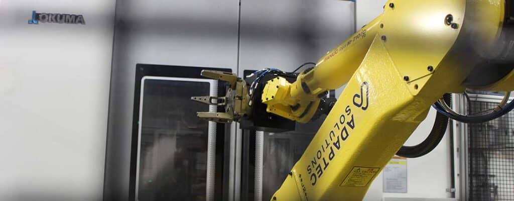 Yellow industrial robot through safety cage