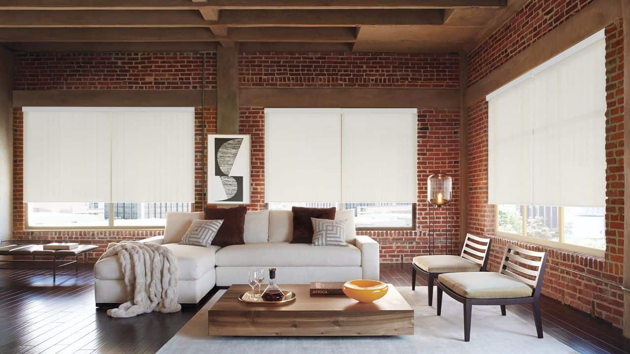 Modern interior with white window blinds and exposed brick walls, showcasing stylish window treatments by Advance Blinds & Drapery. Perfect for enhancing home decor with custom blinds and shades.