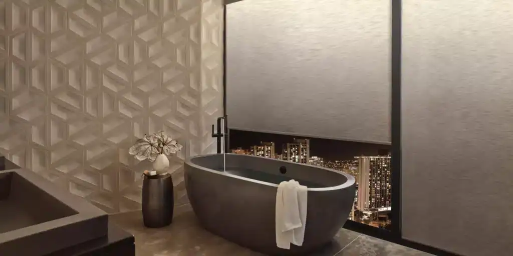 Elegant freestanding bathtub with city view at night, modern bathroom design, textured wall coverings, and stylish decor from Advance Blinds & Drapery.
