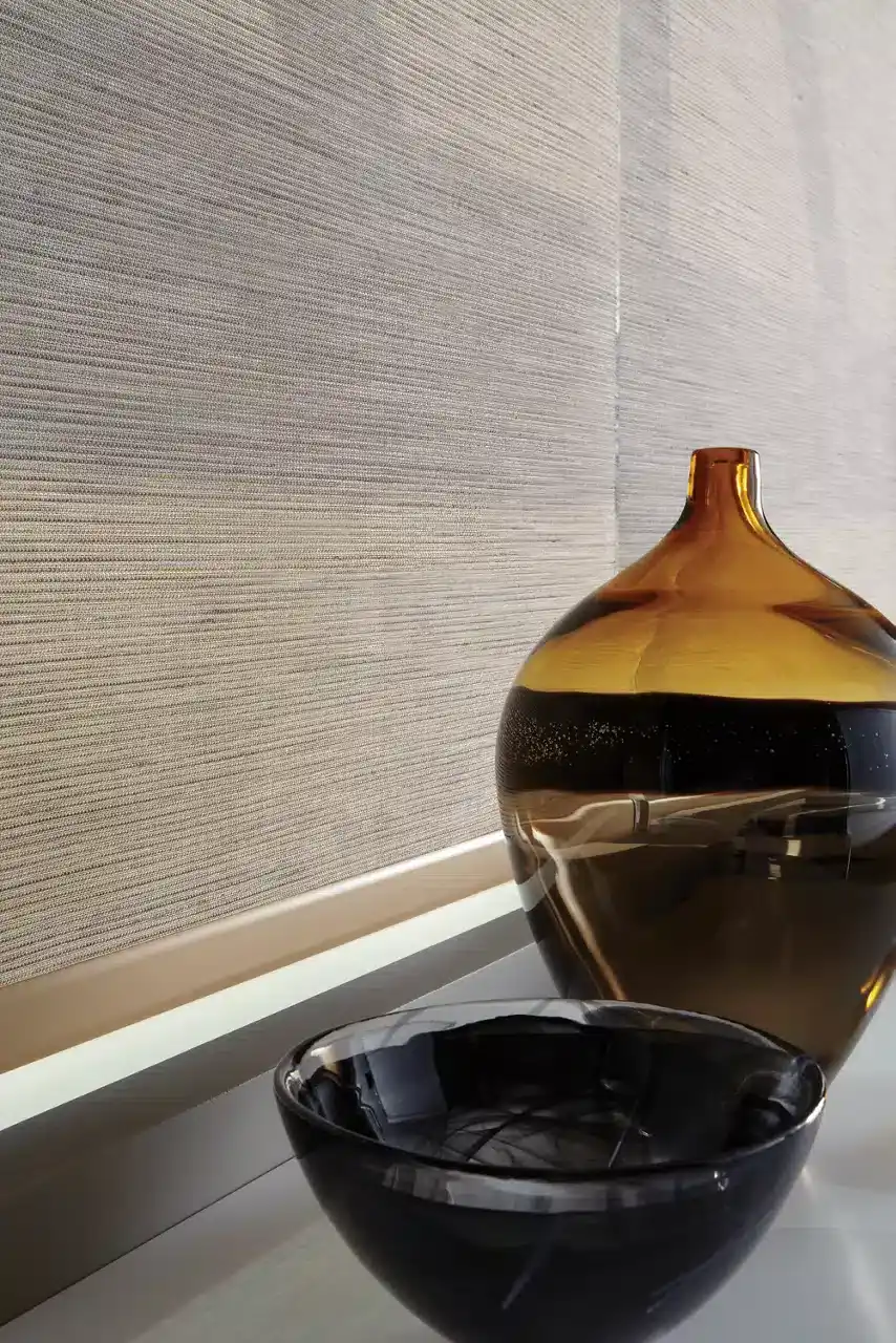 Sleek textured wall with modern decor, featuring a decorative glass vase and bowl, highlighting contemporary interior design elements for homes and offices.