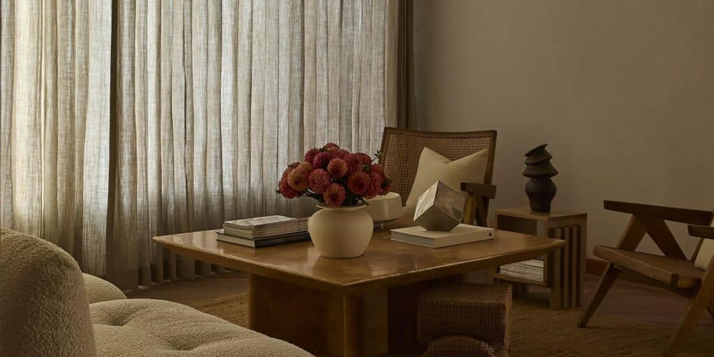 Luxurious living room featuring beige linen curtains, wooden furniture, and elegant decor in a sophisticated home interior setting.