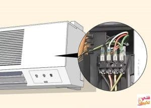 تصليح فني تكييف هندي بالكويت، مرفق صورة لفني كهربائي يتعامل مع لوحة تحكم مكيفة الهواء في الكويت.