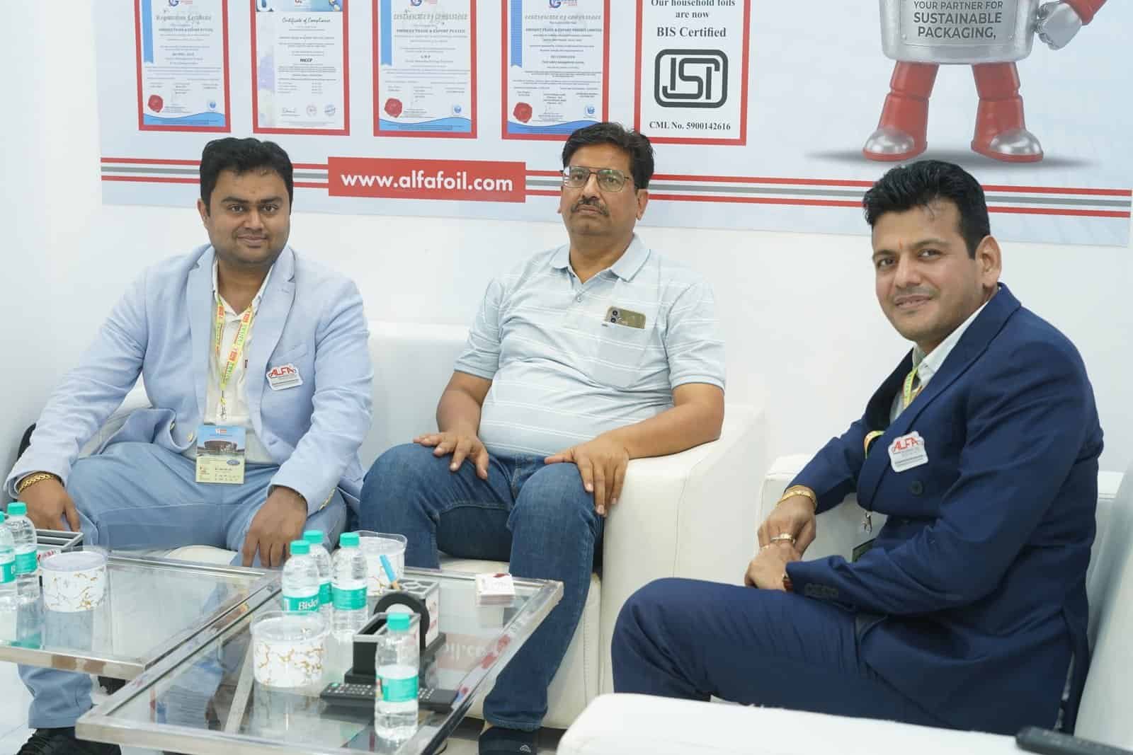 Alfa Foil Containers booth with representatives at a trade exhibition.