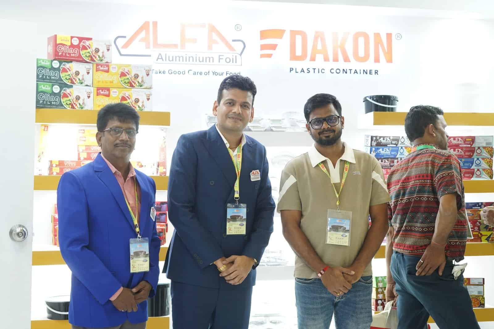 Group of men showcasing Alfa Foil Containers at trade exhibition.