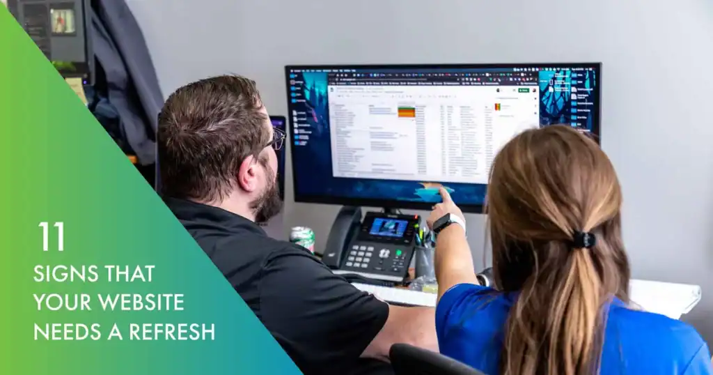 Business professionals analyzing website data on dual monitors for website refresh.