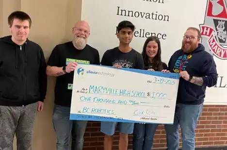 Group of students and mentors holding a large check for STEM education support.